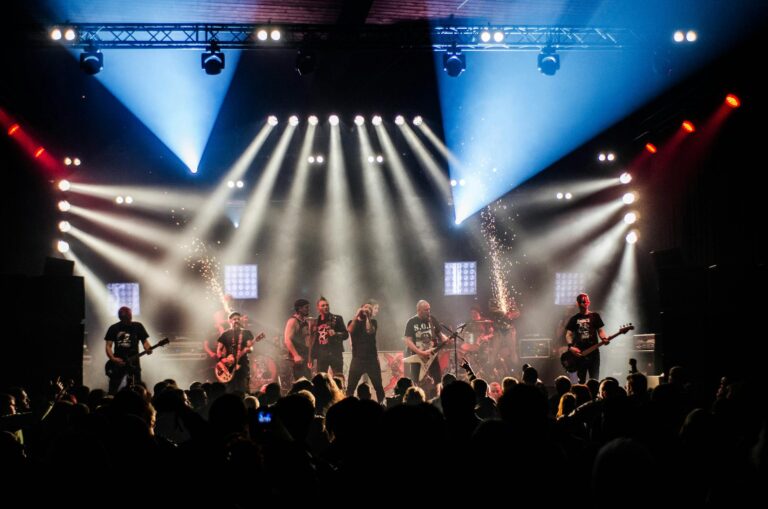 Energetic live band performance under vibrant stage lights captivating a large audience.