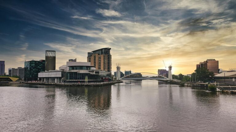 A stunning view of Salford Quays at sunset with modern architecture reflecting on the water.