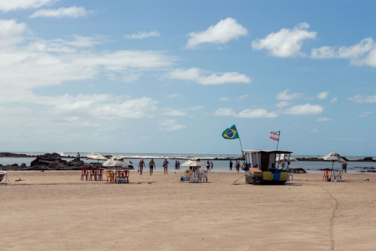 Beachgoers and Brazilian flags at Morro de São Paulo, Bahia on a sunny day.
