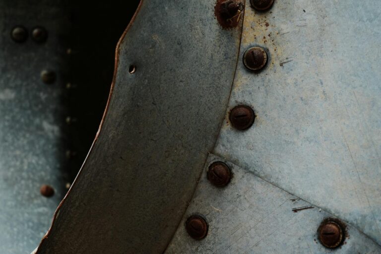Close-up of a rusty metal surface with bolts and rivets creating an industrial texture.