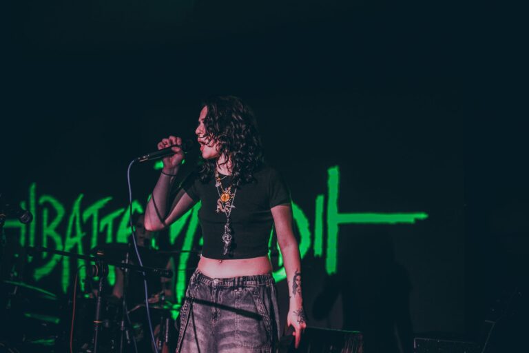 Capture of a woman passionately singing at a live music concert.