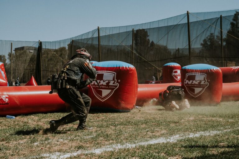 Dynamic outdoor paintball game with players in action on a vibrant field.