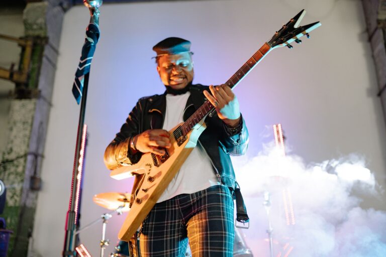 Vibrant live performance of a guitarist in action with smoke effect on stage.