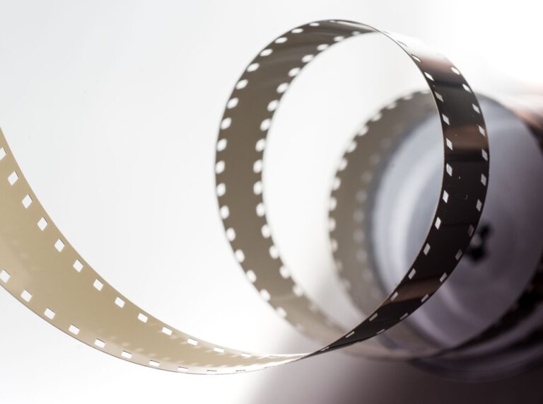 Close-up artistic view of a vintage filmstrip in a spiral design, highlighting its metallic texture.