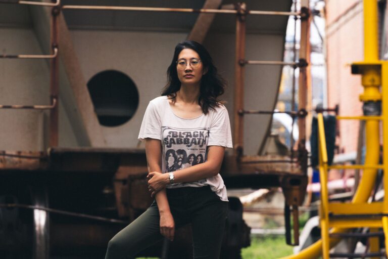 Woman standing outdoors wearing a Black Sabbath shirt and eyeglasses