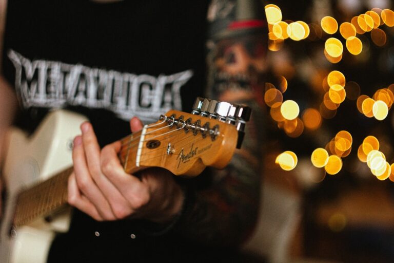 Um Homem Que Toca Uma Guitarra Na Frente De Uma Arvore De Natal _HJgsTqt_RM