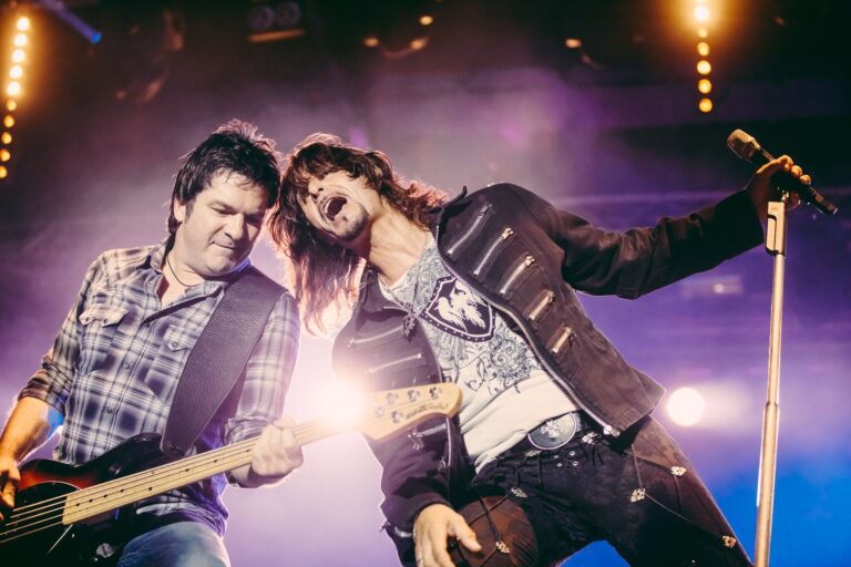 Energetic rock concert with dynamic guitar and vocal performance on stage under bright lights.